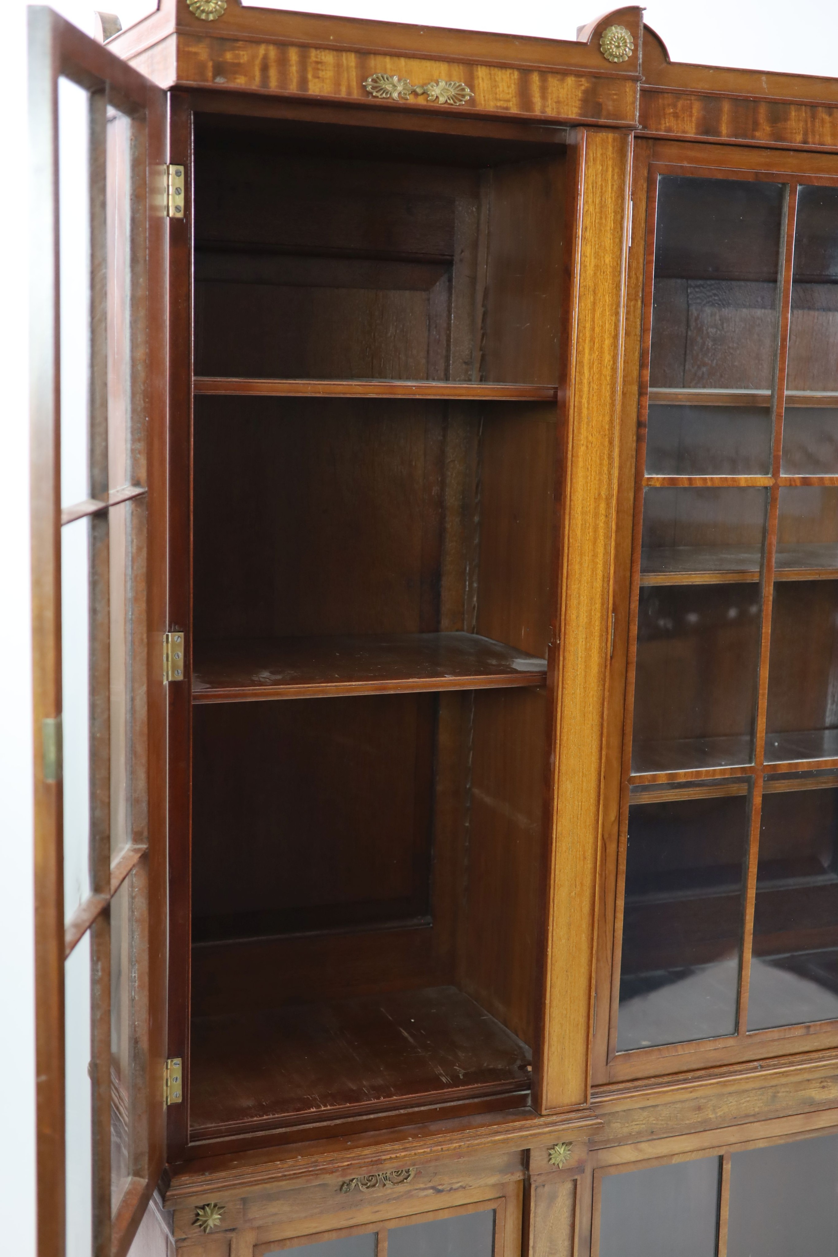 A Regency style mahogany inverse breakfront bookcase H 205cm. W 240cm. D 38cm.